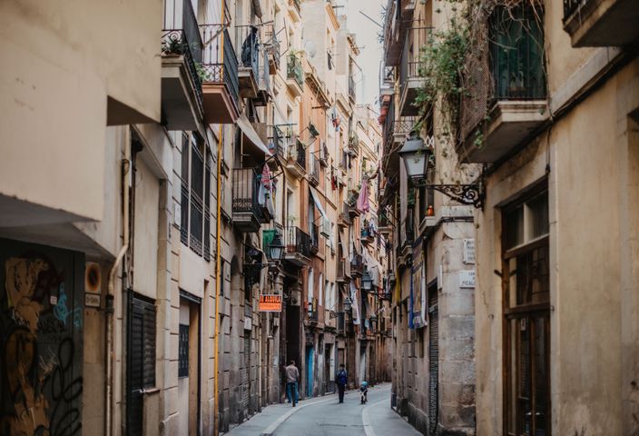 Explore the narrow, historic street in Barcelona's Gothic Quarter with vibrant architecture.