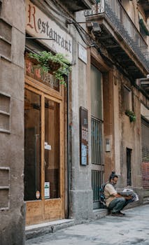 Man reads newspaper outside a restaurant in Barcelona's Gothic Quarter.