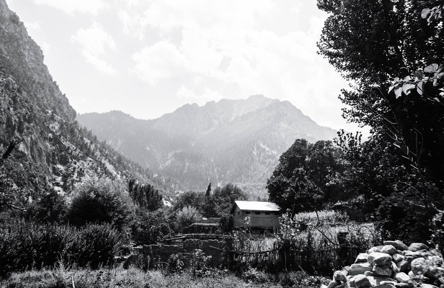 Breathtaking black and white view of Chitrāl's mountains and rural landscape in Pakistan.