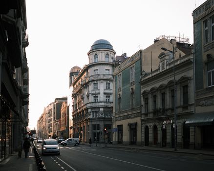 Quiet European street with historical buildings during sunrise, capturing early morning atmosphere.