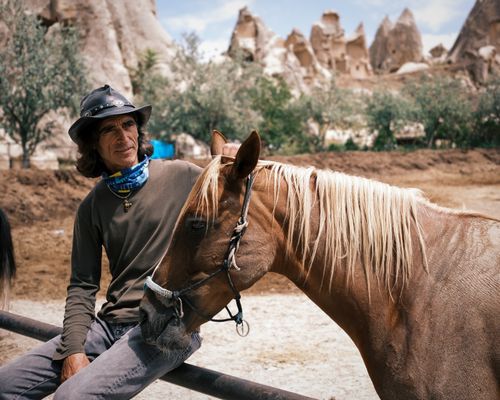 Free A cowboy with a horse amidst the unique rock formations of Cappadocia, Turkey. Stock Photo
