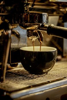 Close-up of espresso machine brewing fresh coffee in a Kermanshah café.