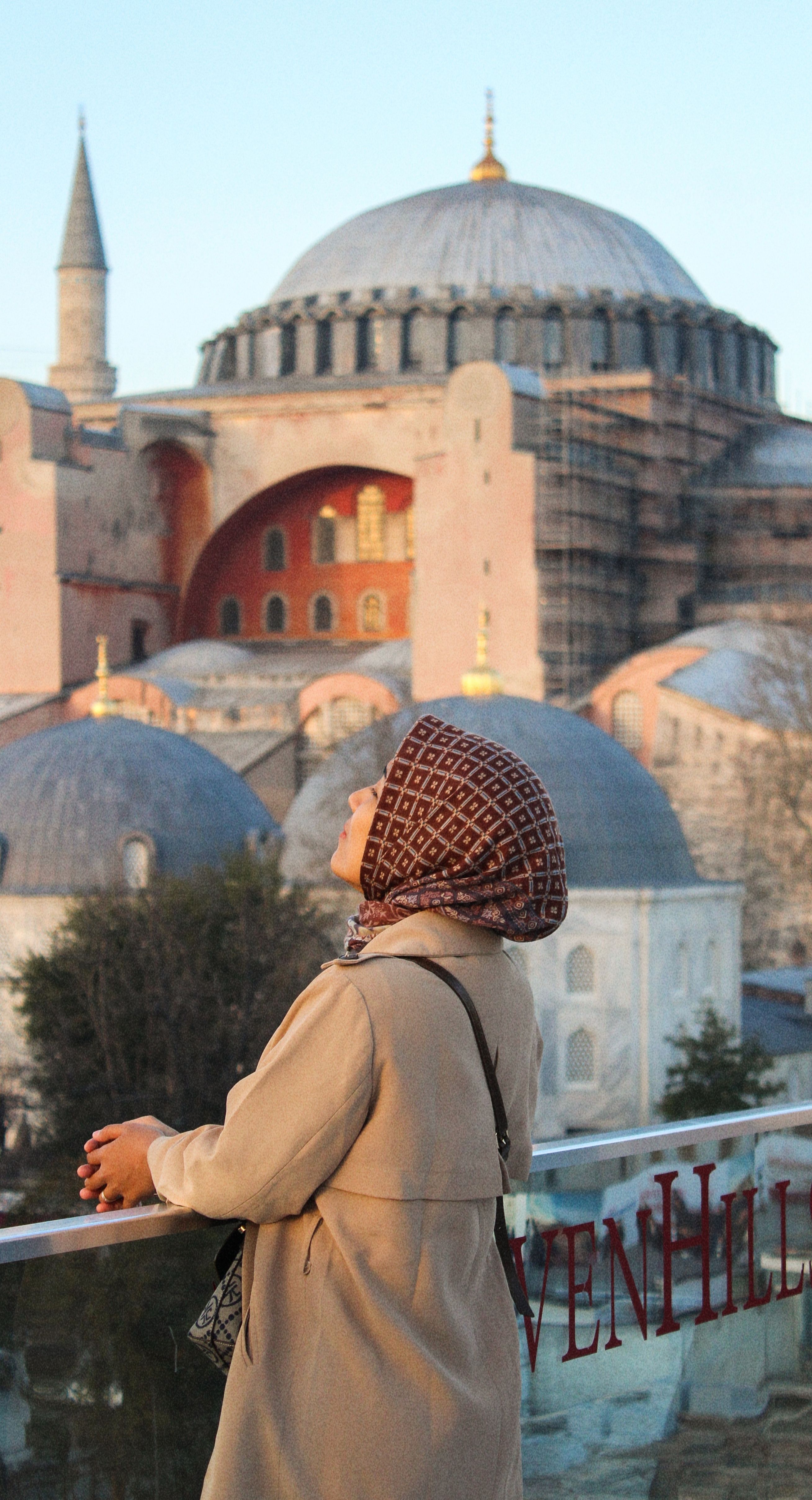 A woman in a hijab observing the historical Hagia Sophia in Istanbul, Turkey.
