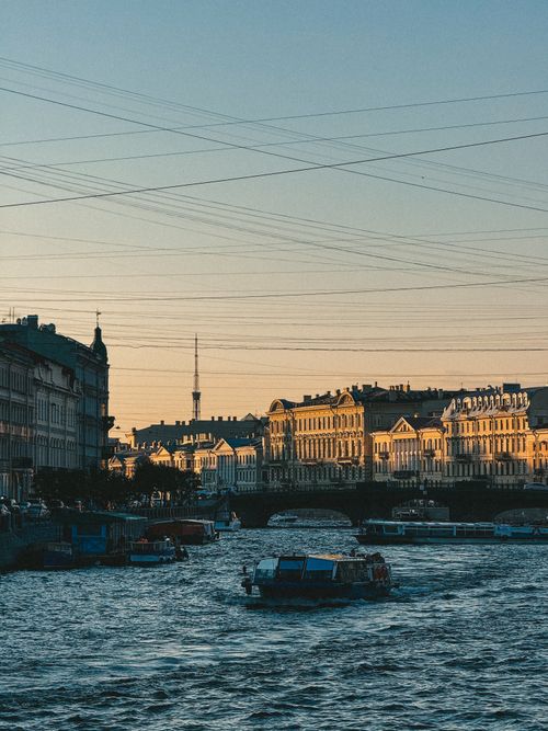 Free A beautiful sunset view of a European riverfront with historic buildings. Stock Photo