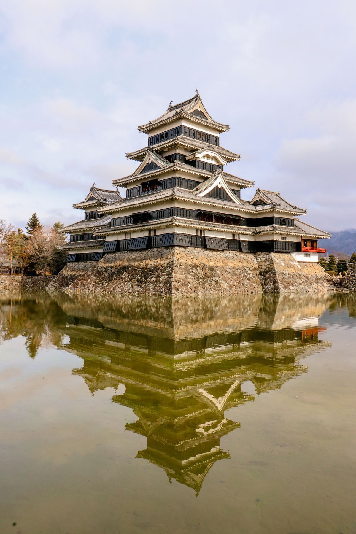 Black Japanese castle reflected in moat — Japan's original timber castle architecture, as exemplified by Matsue Castle in Shimane Prefecture