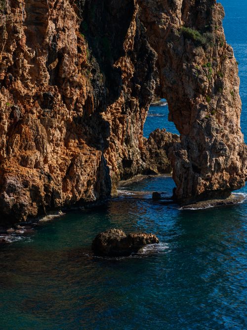 Free Stunning view of a natural rock arch by the ocean, ideal for seascape photography. Stock Photo