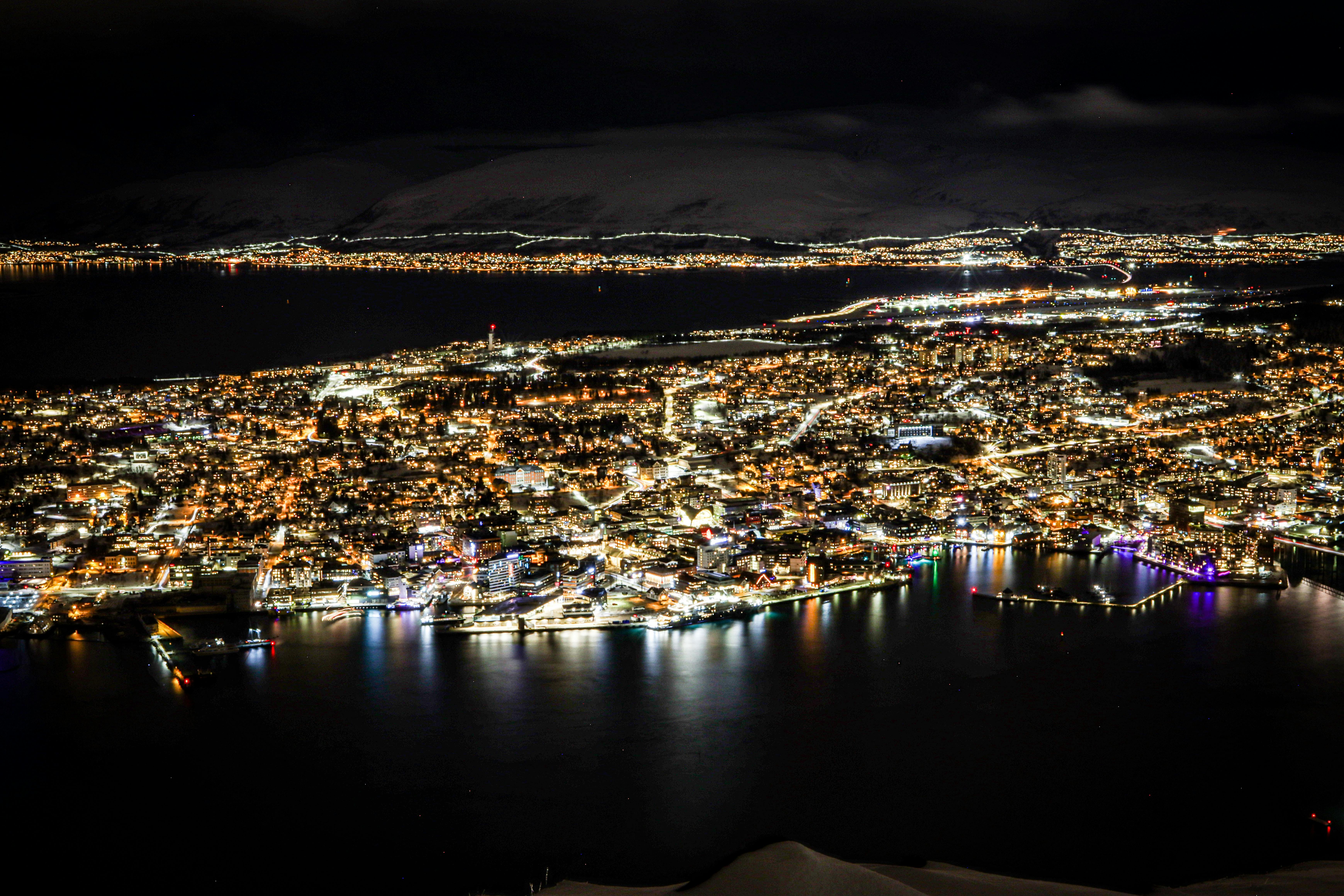 Stunning aerial view of Tromsø, Norway by night with illuminated cityscape.