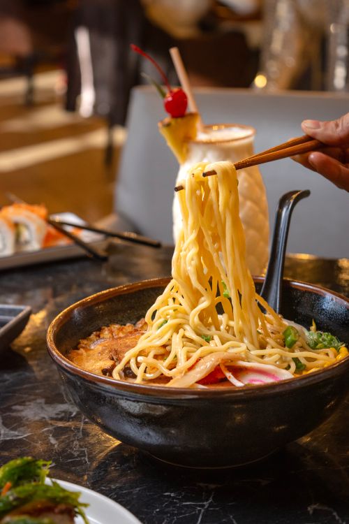 Free Savor the taste of ramen in a cozy Mexican setting with vibrant lighting. Stock Photo