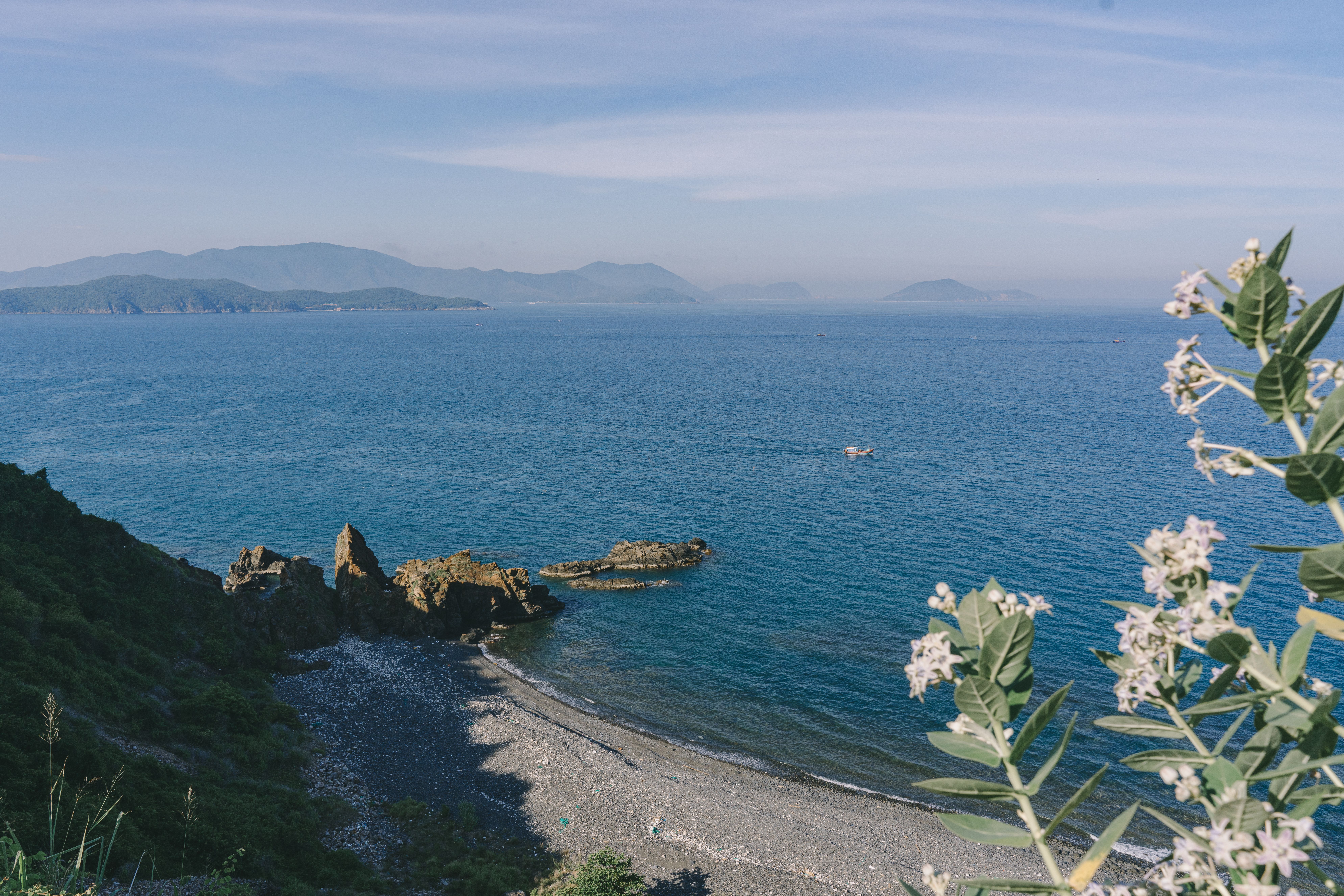 Beautiful coastal view of Nha Trang, capturing rocky shores and ocean waves under a clear sky.