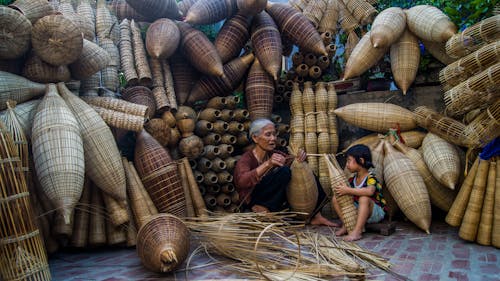 Woman Sitting Beside Girl Holding Brown Wicker Basket