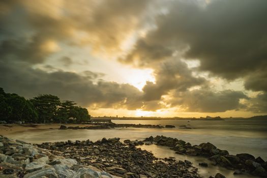 Dramatic sunset over rocky shores at Galle Beach, Sri Lanka.