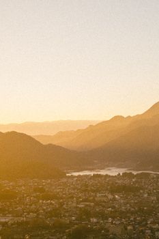 A serene mountain view at sunset with warm tones over a town.