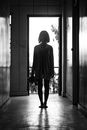 一名女子站在走廊里，喜怒无常的黑白剪影唤起神秘与沉思