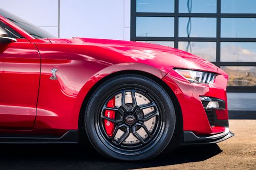 Free Side view of a sleek red sports car featuring distinctive Cobra logo, vibrant brake calipers, and modern alloy wheels. Stock Photo