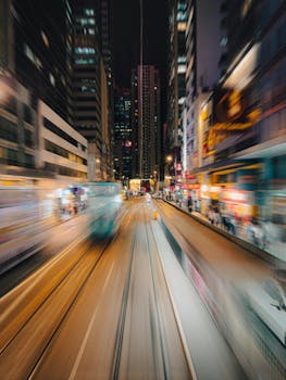 Long exposure of Hong Kong's bustling cityscape at night showcasing dynamic urban energy and iconic trams.