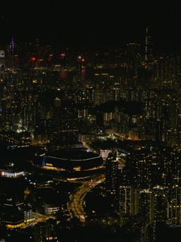 A stunning aerial view of Hong Kong's vibrant urban landscape at night, showcasing dazzling skyscrapers and bustling streets.