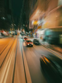 Blurred motion of night traffic on bustling Hong Kong streets showcasing vibrant urban life.