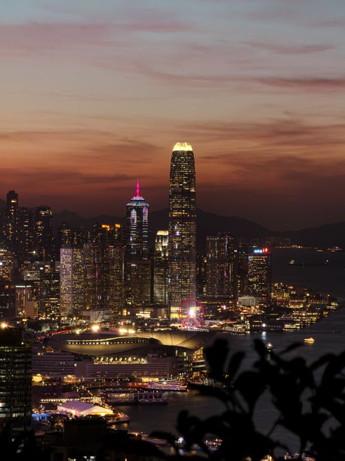 Free Breathtaking view of Hong Kong's vibrant skyline featuring skyscrapers and Victoria Harbour at sunset. Stock Photo