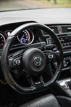 Detailed view of a Volkswagen car steering wheel and dashboard.