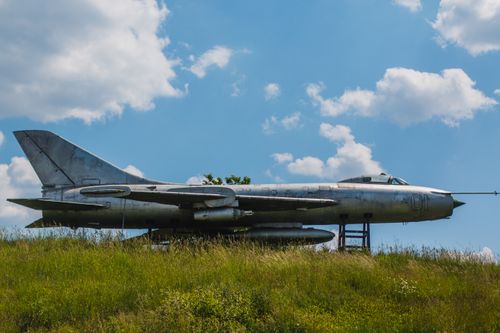 Free Vintage jet fighter aircraft displayed outdoors under a bright blue sky. Stock Photo