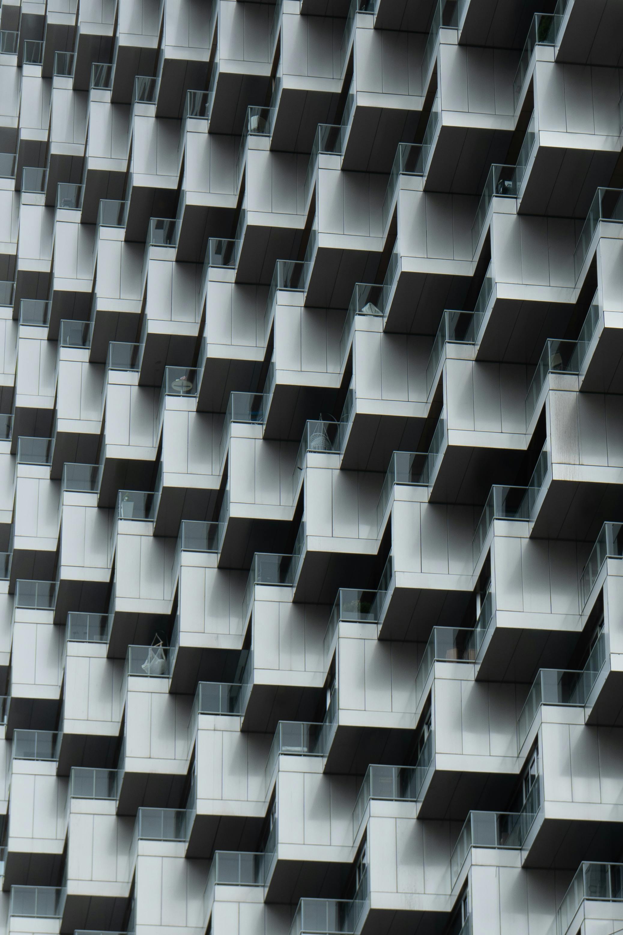 High-rise building facade showcasing geometric, interlocking balcony patterns in a modern urban setting.
