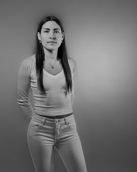 Black and white portrait of a young woman in casual attire, creating a serene and timeless feel.