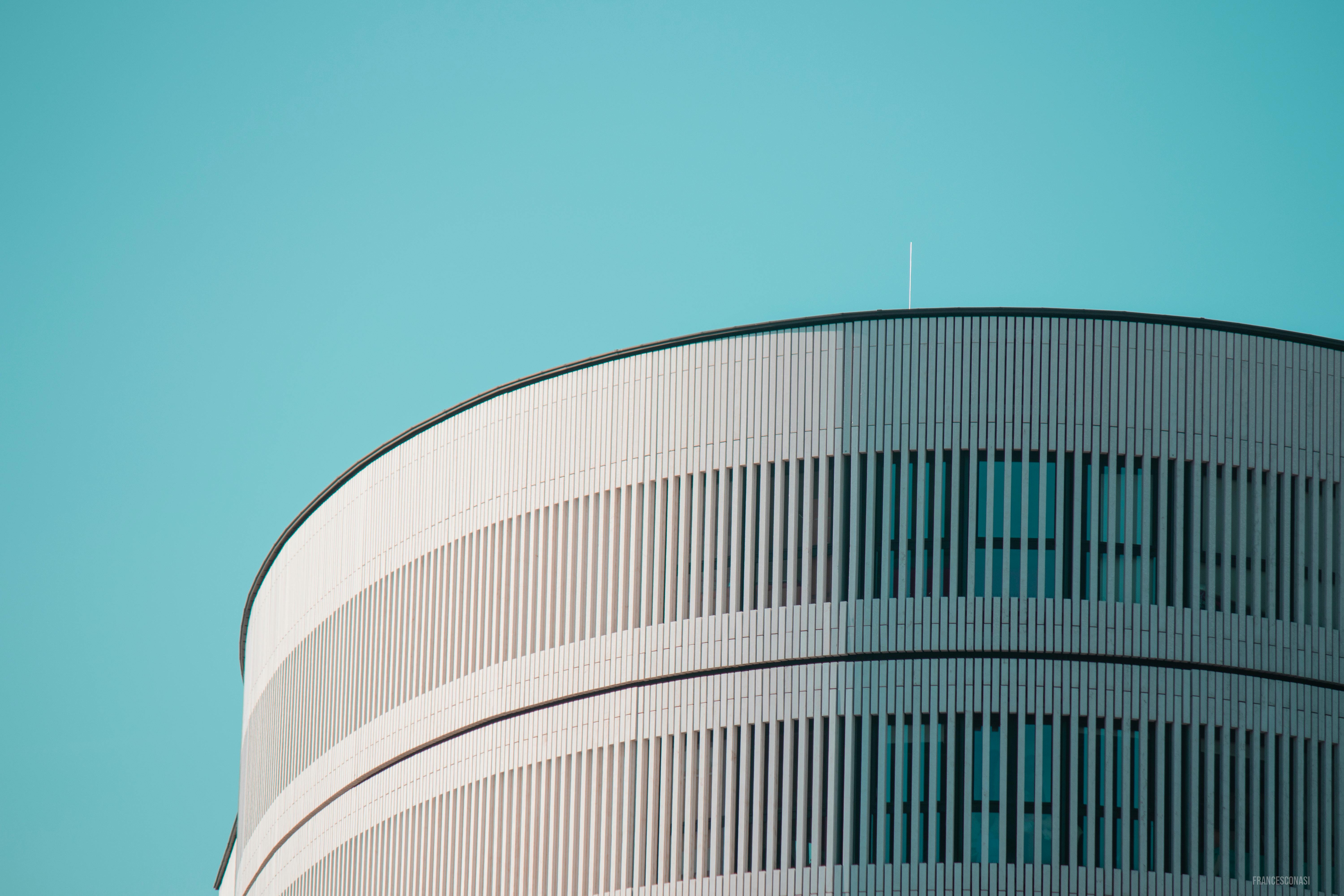 Free Striking modern cylindrical building with sleek design against a clear blue sky in Milan, Italy. Stock Photo