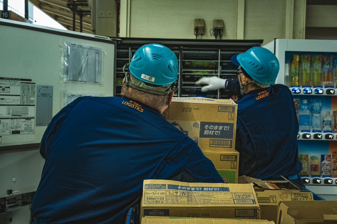 Optimisation des coûts du courrier industriel en entreprise Opérateurs d'entrepôt gérant des boîtes logistiques près d'équipements industriels