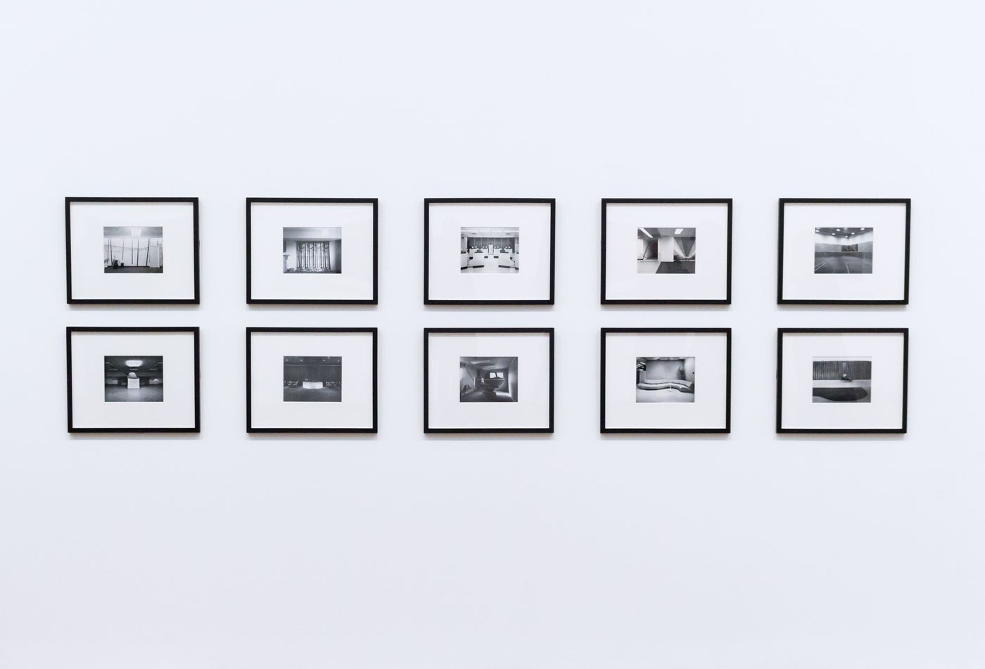 Black-and-white framed prints hung on a white gallery wall