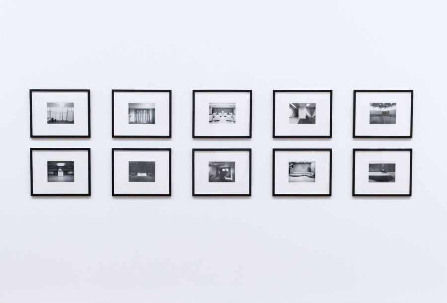 A framed photograph in a plain wooden moulding with a wide off-white mount.