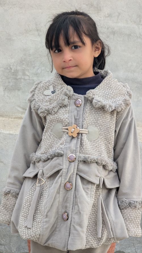 Free A young South Asian girl wearing a stylish coat, smiling outdoors in Punjab. Stock Photo