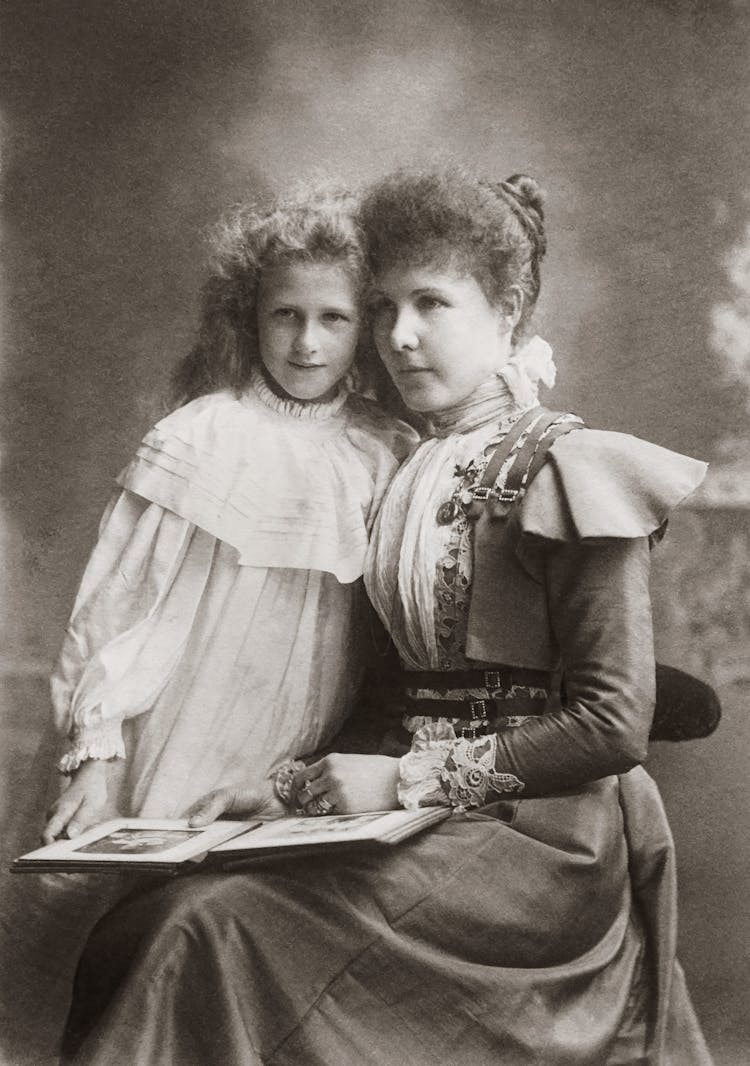 Vintage Photo Of Mother Sitting With A Photo Album Beside Her Child 