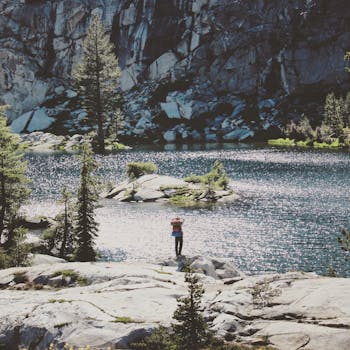 一位孤独的徒步旅行者，正享受着被岩石山脉环绕的宁静湖泊