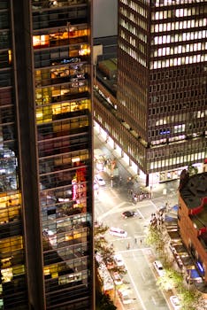 A bustling city intersection at night with illuminated skyscrapers.