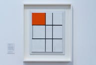 画廊里展出了极简主义风格的几何艺术，以大胆的红色方块为特色