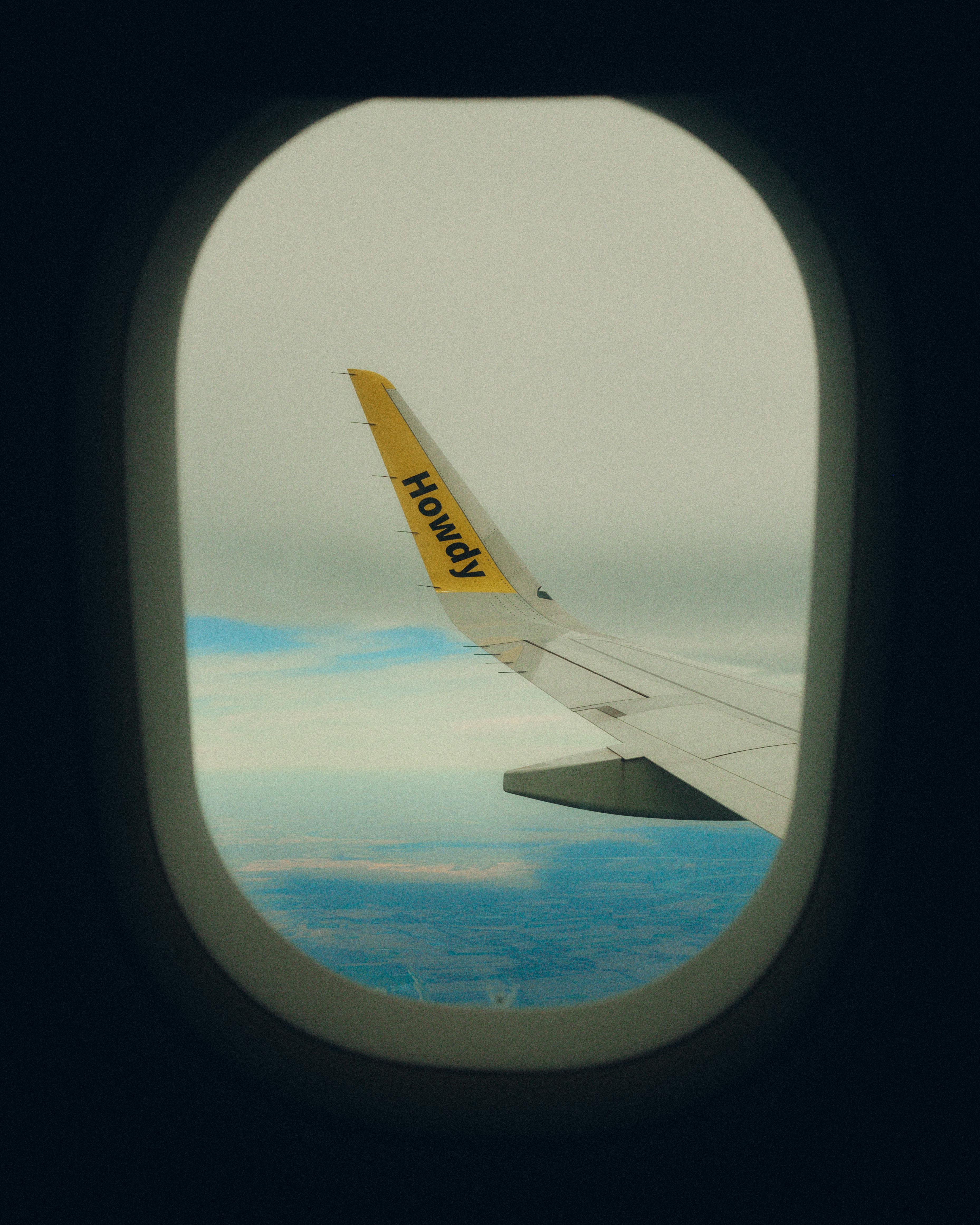 View from airplane window capturing a scenic aerial view through the wing tip.