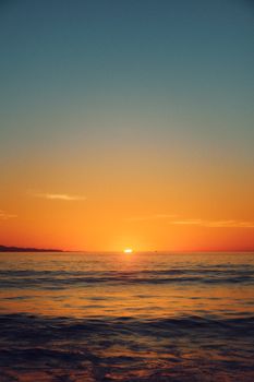 Golden hues of sunset across tranquil Oxnard beach. A peaceful nature retreat.