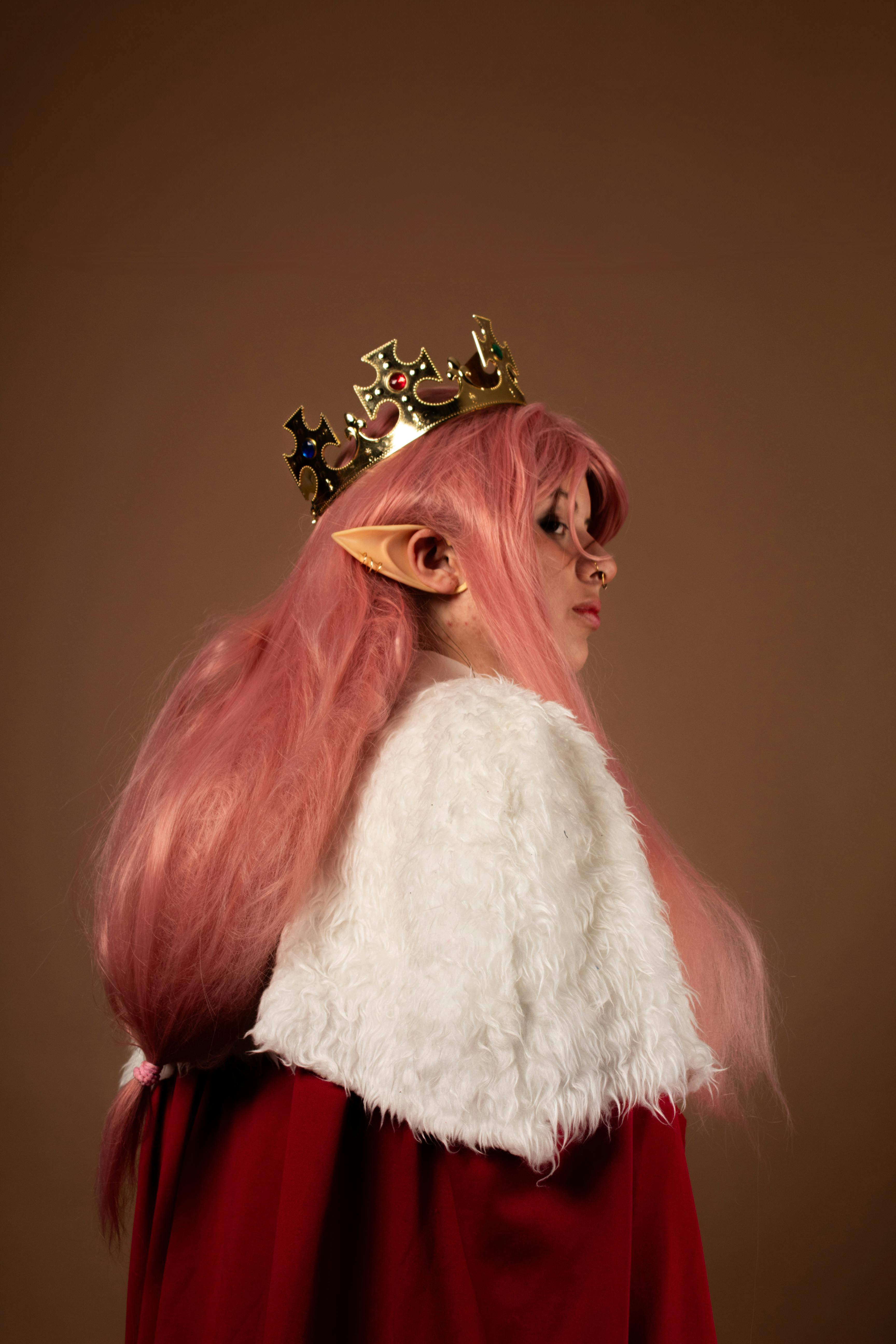 Ücretsiz Pembe saçlı, elf kulaklı ve taç takan bir kadının yer aldığı, fantezi temalı bir cosplay portresi. Stok Fotoğraflar