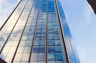 现代玻璃摩天大楼在低角度拍摄下映出蓝天和云彩