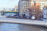 千禧桥上栖息着一只海鸥，可以看见伦敦的河流和标志性建筑