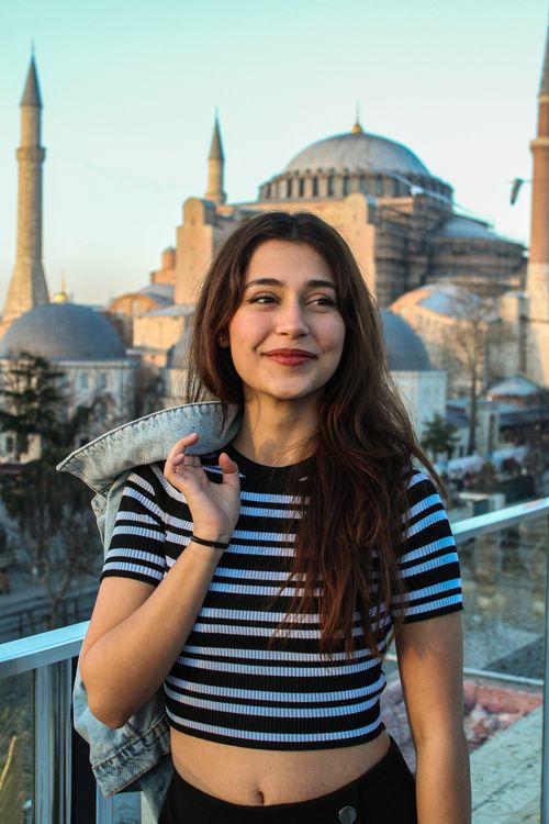 Free Happy woman standing on a rooftop with Hagia Sophia in the background, Istanbul. Stock Photo