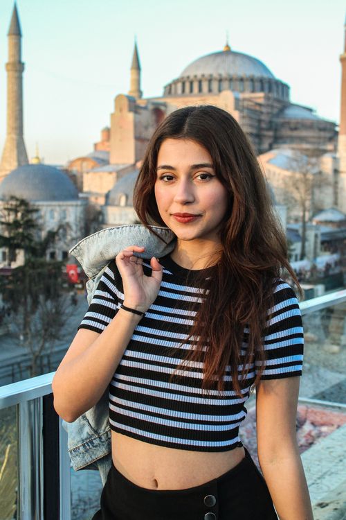 Free Young woman posing with Hagia Sophia backdrop in Istanbul, vibrant and modern. Stock Photo