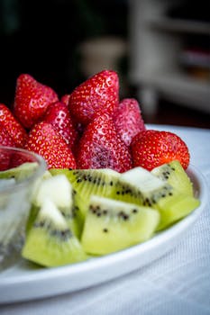 A vibrant platter of fresh strawberries and kiwi slices, perfect for a healthy snack.