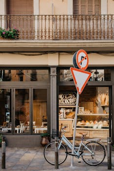 Street scene in Barcelona with a bakery, bicycle, and signage.