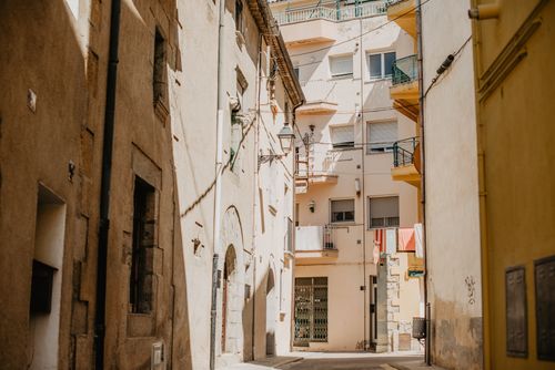 Free Charming sunny alley in Mediterranean town with rustic architecture. Stock Photo