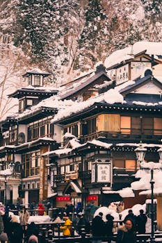 A scenic view of a traditional Japanese onsen surrounded by snow-covered trees, capturing seasonal beauty.