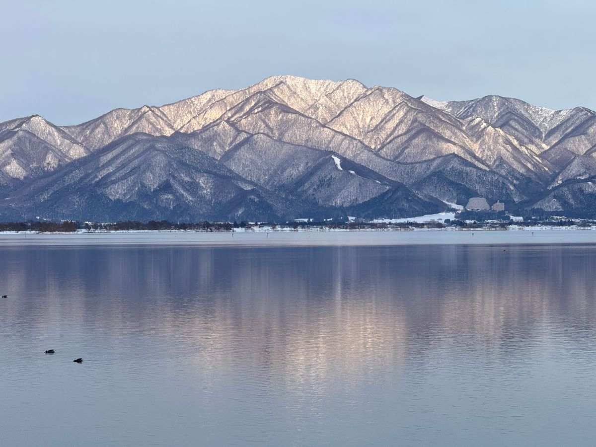 Lake Inawashiro in winter — snow-capped Bandai mountains reflected in still water, Fukushima Prefecture