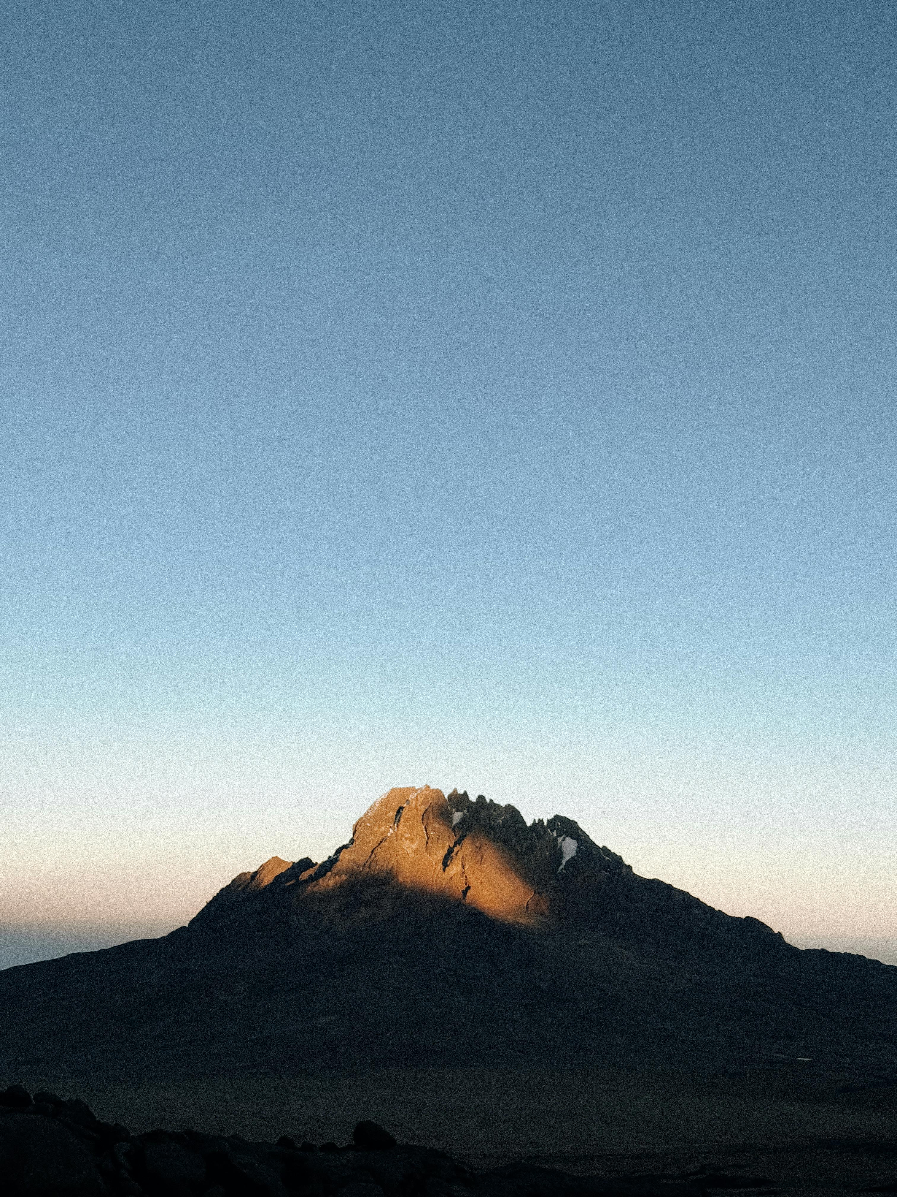 Breathtaking view of Mount Kilimanjaro at sunrise, showcasing its majestic peak and serene atmosphere.