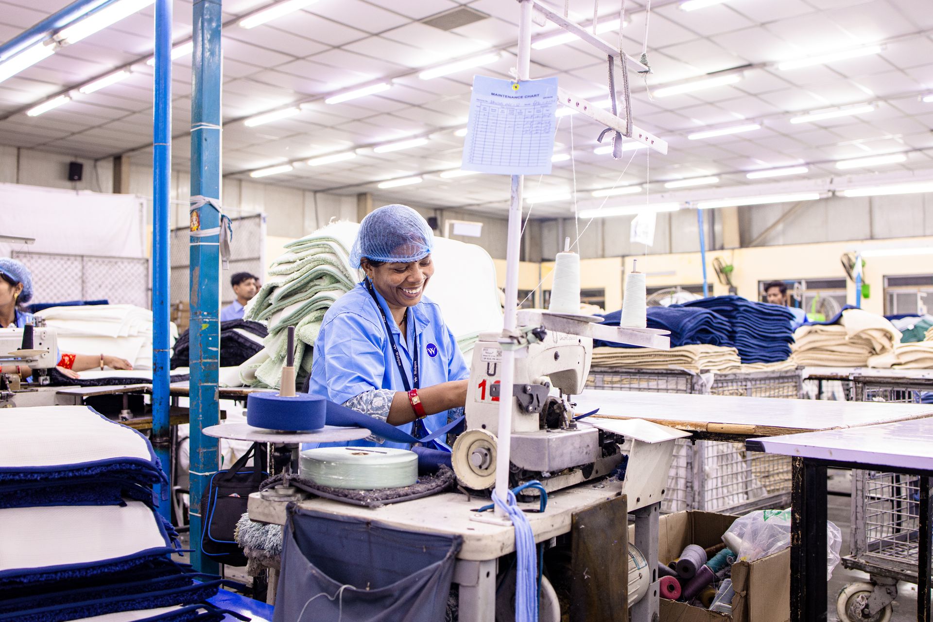 Factory worker operating a sewing machine in a textile factory