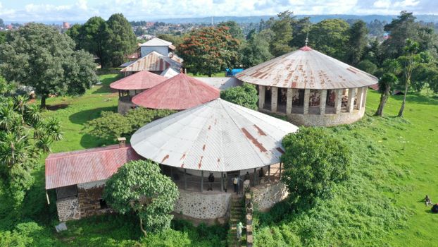 Aerial shot of circular buildings surrounded by lush greenery in Nekemte, Ethiopia.